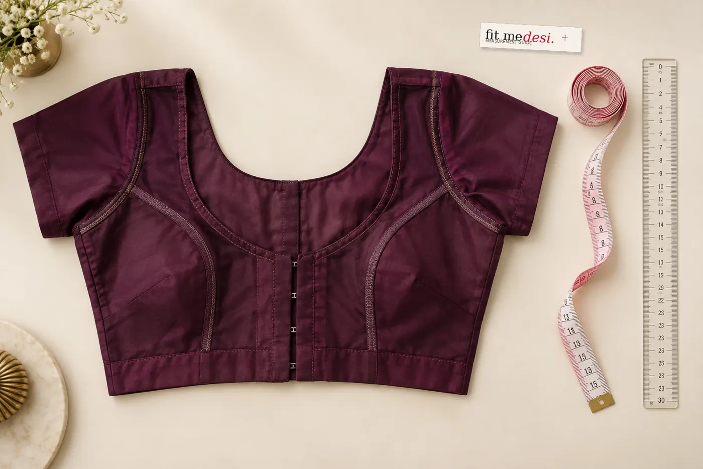 Inside-out blouse laid flat with both a measuring tape and a scale ruler ready